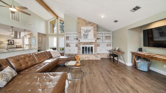 living room featuring lofted ceiling with beams, ceiling fan, a fireplace, and hardwood / wood-style floors