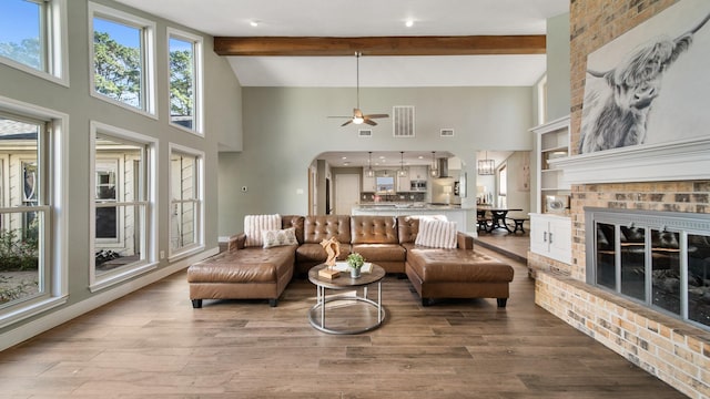 living room featuring plenty of natural light, beam ceiling, and light hardwood / wood-style floors