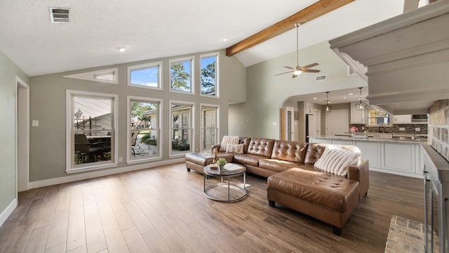 living room with ceiling fan, hardwood / wood-style flooring, high vaulted ceiling, and beamed ceiling