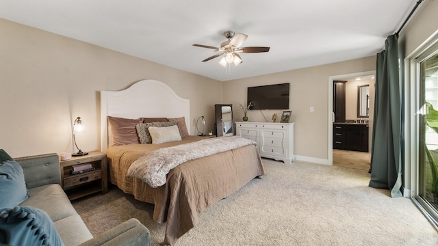 bedroom featuring ceiling fan, light colored carpet, and ensuite bath