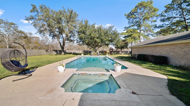 view of swimming pool with an in ground hot tub, a patio area, and a lawn