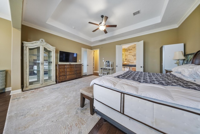 bedroom with crown molding, ceiling fan, dark hardwood / wood-style flooring, and a raised ceiling