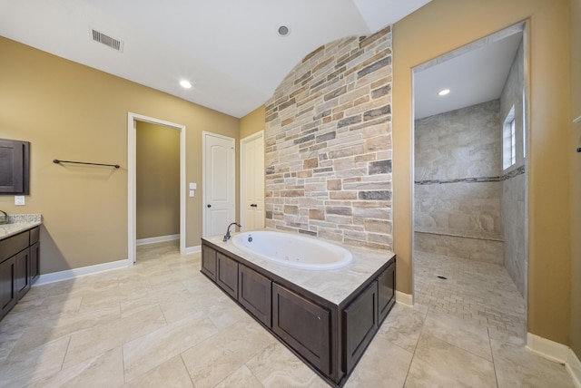 bathroom featuring vaulted ceiling, vanity, and separate shower and tub