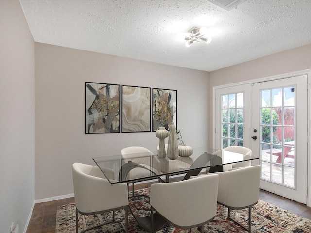 dining area featuring a textured ceiling and french doors