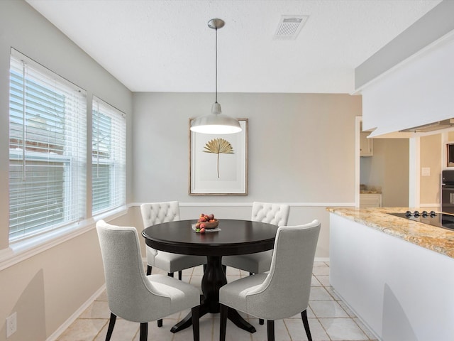 dining room featuring a textured ceiling and light tile patterned floors