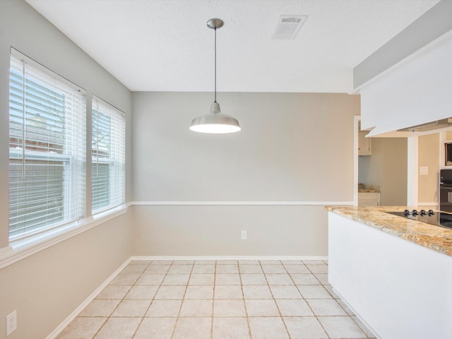 unfurnished dining area featuring a textured ceiling