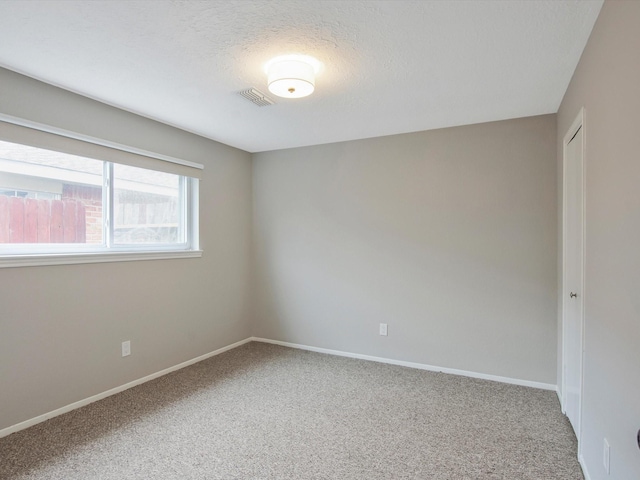 carpeted empty room with a textured ceiling