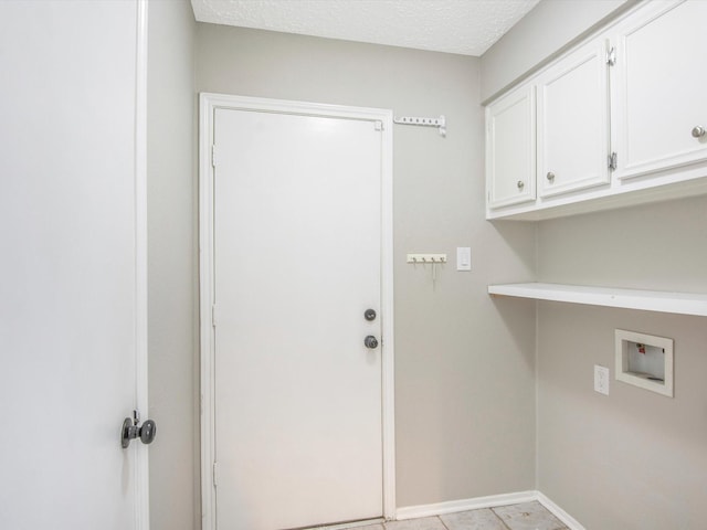 clothes washing area featuring washer hookup, cabinets, and a textured ceiling