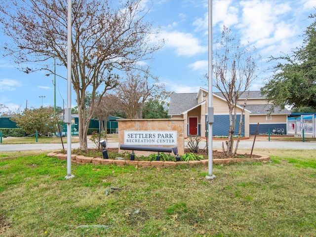 community / neighborhood sign with a yard