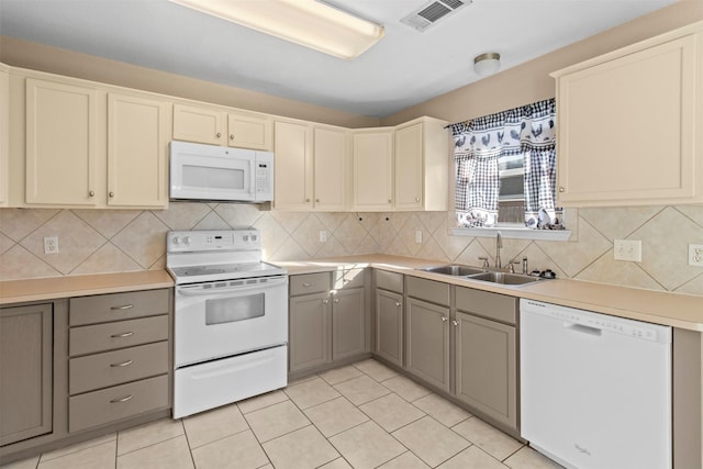 kitchen featuring tasteful backsplash, light tile patterned flooring, sink, and white appliances