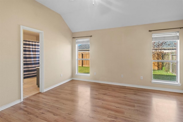 unfurnished bedroom featuring lofted ceiling and light hardwood / wood-style floors