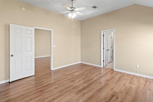 empty room featuring ceiling fan, vaulted ceiling, and light hardwood / wood-style floors