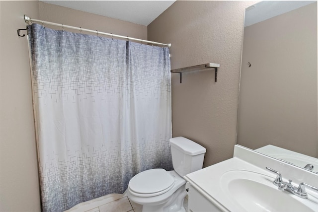 bathroom with tile patterned flooring, vanity, and toilet