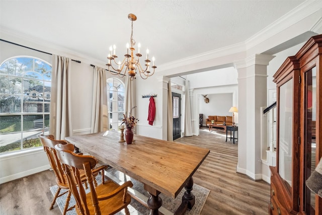 dining area with ornamental molding, decorative columns, and hardwood / wood-style floors