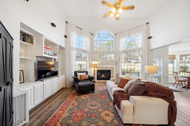 living room with a healthy amount of sunlight, dark hardwood / wood-style floors, and a high ceiling