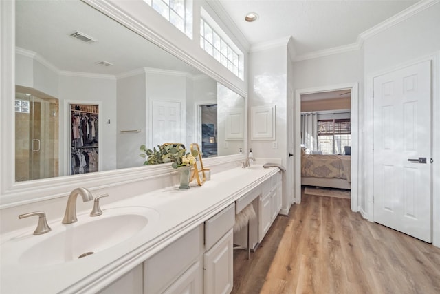 bathroom featuring a shower with door, wood-type flooring, vanity, and crown molding