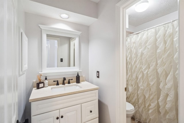 bathroom with vanity, a textured ceiling, curtained shower, and toilet