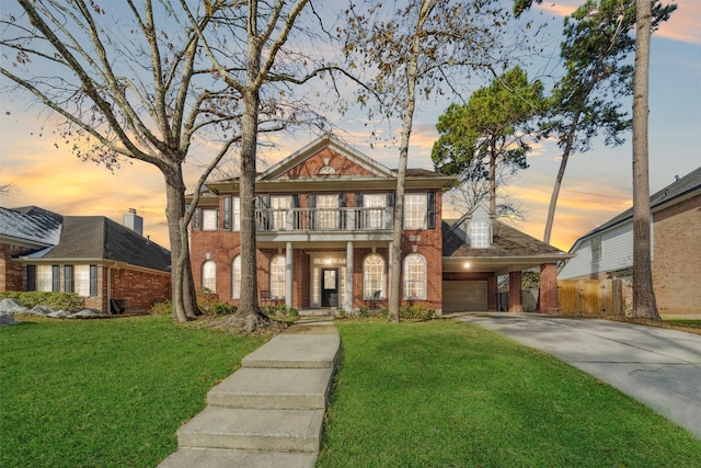 view of front of house featuring a balcony, a garage, and a lawn