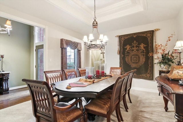 dining room featuring crown molding, carpet flooring, a notable chandelier, and a tray ceiling