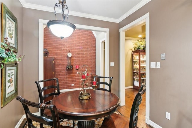 dining space with ornamental molding and light hardwood / wood-style floors