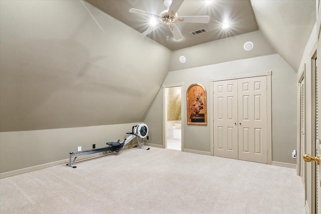 exercise room featuring lofted ceiling, light colored carpet, and ceiling fan