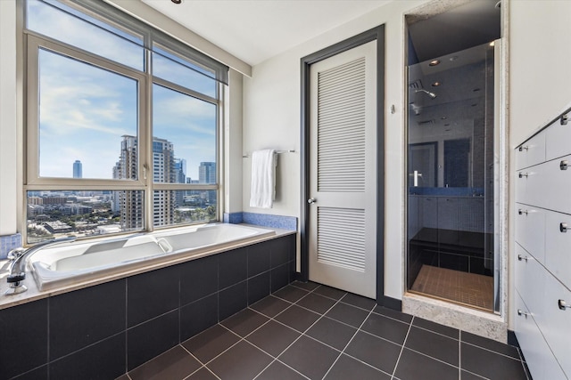 bathroom with tile patterned flooring and tiled bath