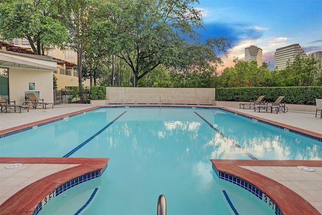 pool at dusk with a patio