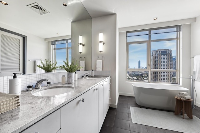 bathroom featuring vanity, a bath, and tile patterned floors