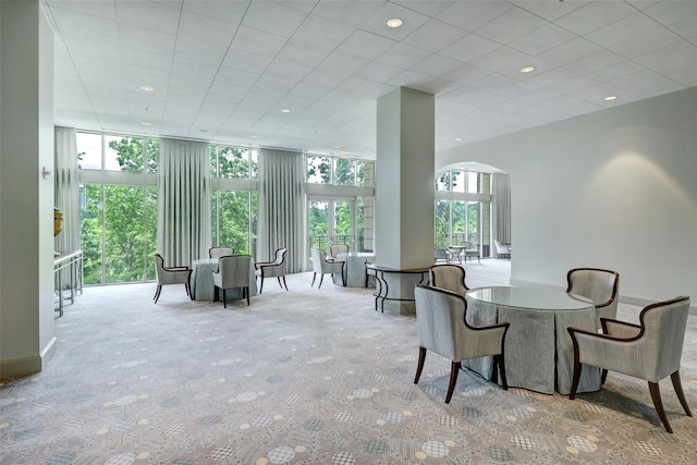 dining room featuring light colored carpet and expansive windows