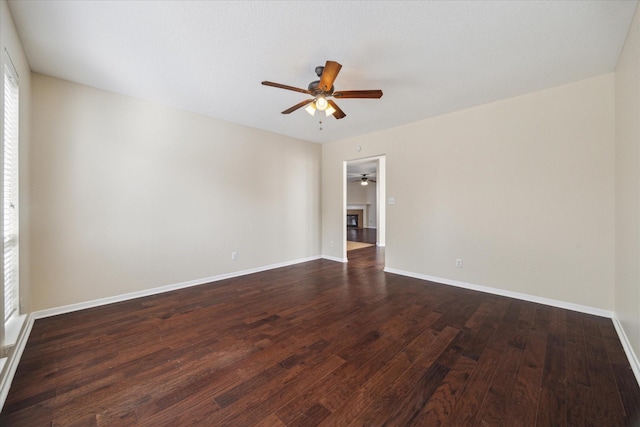 unfurnished room with ceiling fan and dark hardwood / wood-style flooring