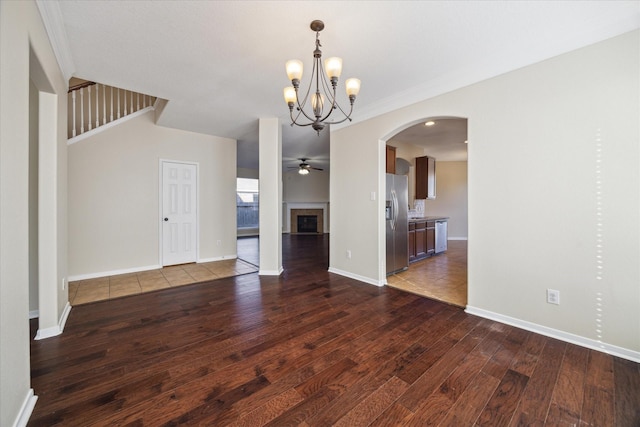 unfurnished dining area with hardwood / wood-style flooring, crown molding, and ceiling fan with notable chandelier