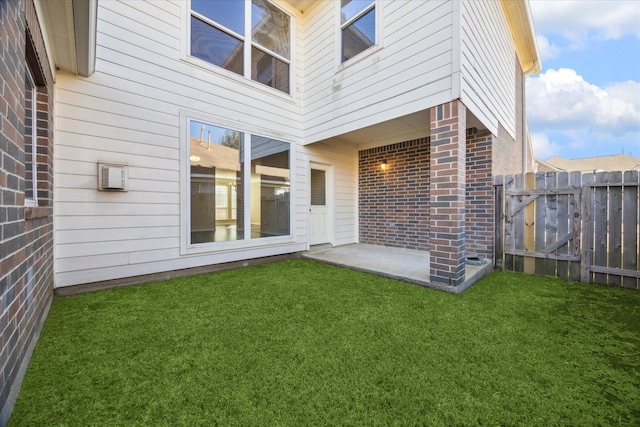 back of house with a patio and a lawn