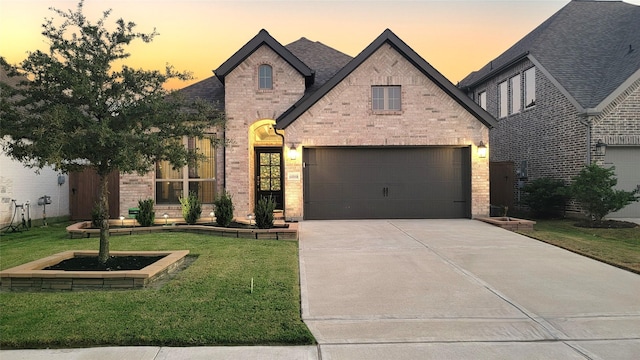 french country home with a garage and a yard