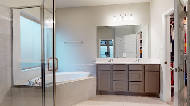 bathroom with tile patterned floors, shower with separate bathtub, and vanity