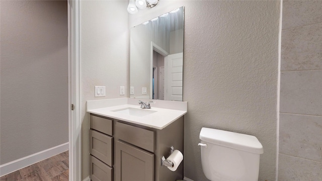 bathroom featuring hardwood / wood-style flooring, vanity, and toilet