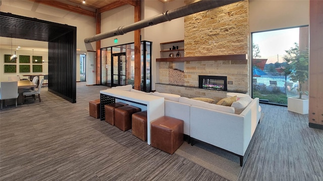 living room featuring beamed ceiling, a towering ceiling, and a fireplace