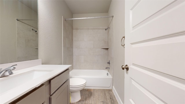 full bathroom with vanity, hardwood / wood-style floors, toilet, and tiled shower / bath