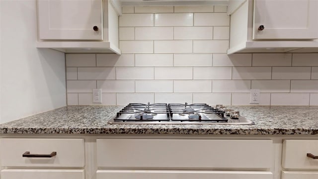 kitchen with white cabinetry, backsplash, and stainless steel gas cooktop