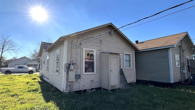 rear view of property with a lawn and central air condition unit