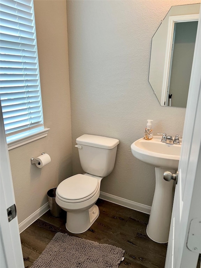 bathroom with toilet and hardwood / wood-style floors