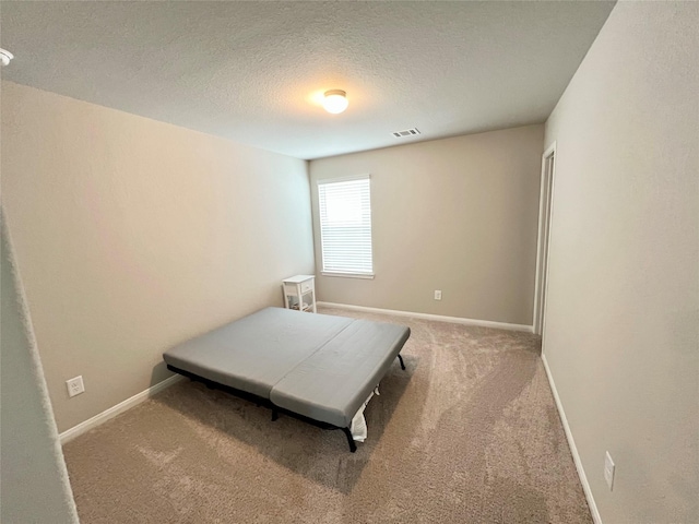 carpeted bedroom featuring a textured ceiling