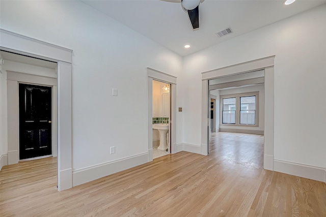 spare room with ceiling fan and light wood-type flooring