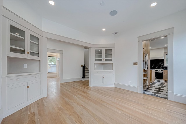 unfurnished living room with light hardwood / wood-style floors and built in features