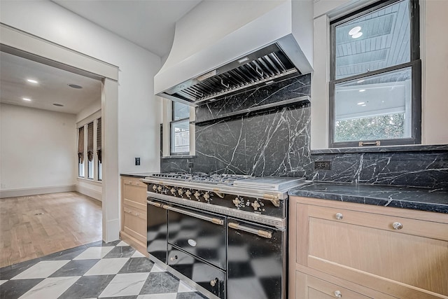 kitchen featuring tasteful backsplash, double oven range, custom range hood, and light brown cabinets