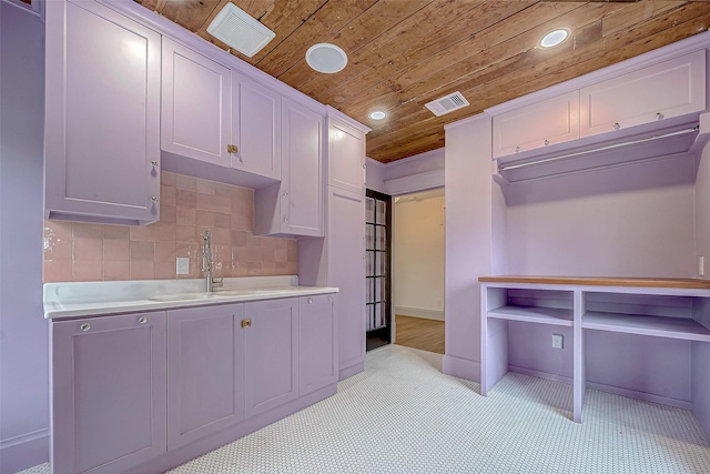 kitchen featuring tasteful backsplash, sink, wood ceiling, and white cabinets