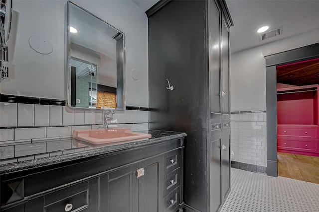 bathroom with vanity and tile walls