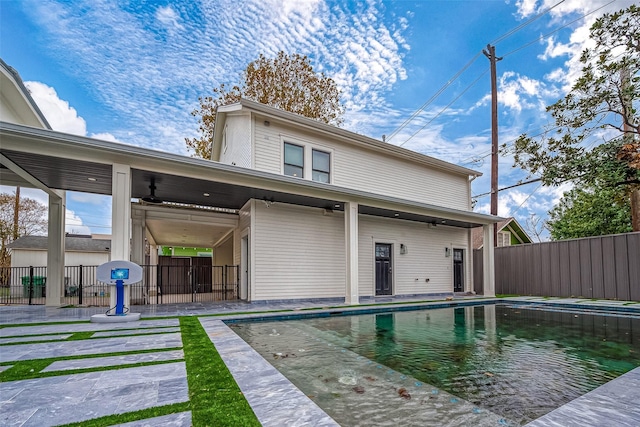 back of house featuring a fenced in pool and ceiling fan