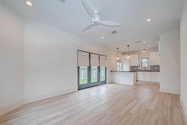 unfurnished living room featuring french doors, ceiling fan, and light hardwood / wood-style floors