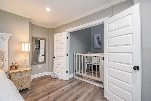 bedroom featuring hardwood / wood-style floors, a crib, and ornamental molding