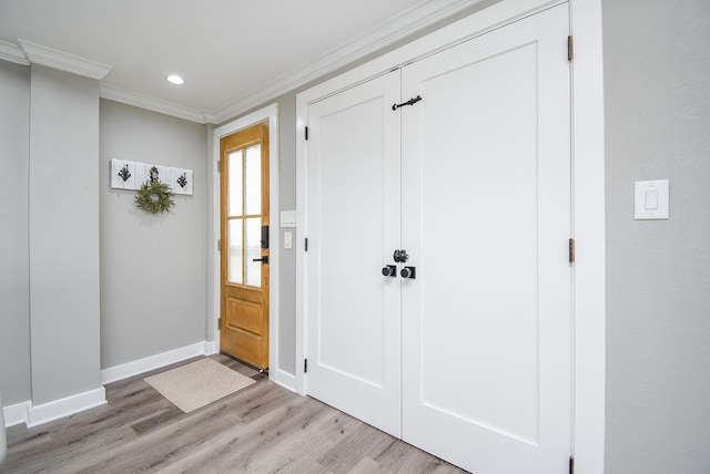 entrance foyer with ornamental molding and light hardwood / wood-style floors